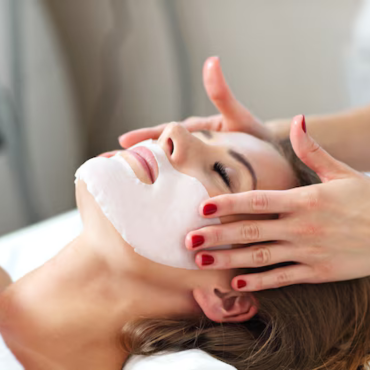 A woman receiving a Hydro Boost facial treatment at Kaya by Reema Salon, showcasing anti-aging and organic peel services.