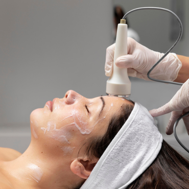 A woman receiving a Hydro Boost facial treatment at Kaya by Reema Salon, showcasing anti-aging and organic peel services.
